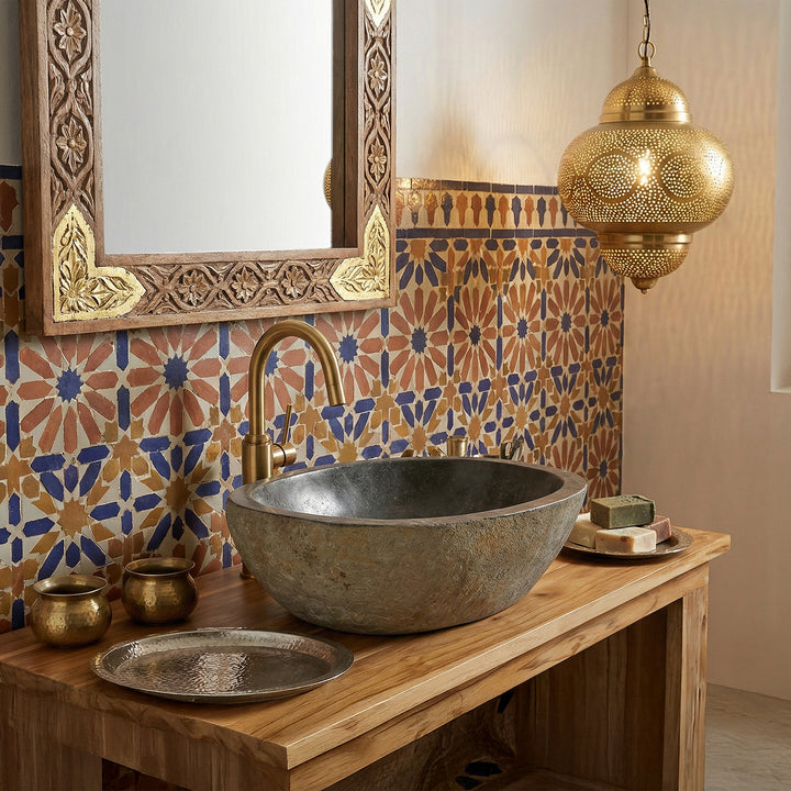 Flodstensvask i det orientaliska badrummet på en träkonsol, kombinerat med mässingsbeslag, mosaikplattor och varmt ljus