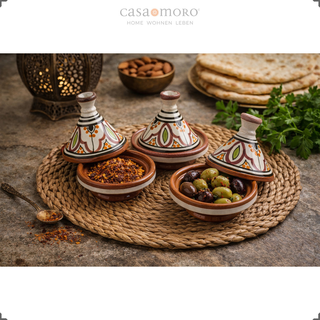 Kryddtagine gjord av lera i en uppsättning om 3 handmålade keramiska kryddbehållare med oliver och kryddor i en orientalisk atmosfär