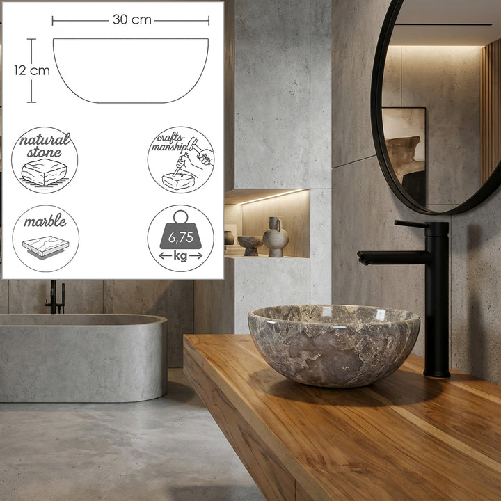 Tvättställ i natursten i gråbrun ådring på träkonsol i det moderna badrummet, med svart fristående armatur och integrerade grafiska mått för diameter, höjd, material och vikt