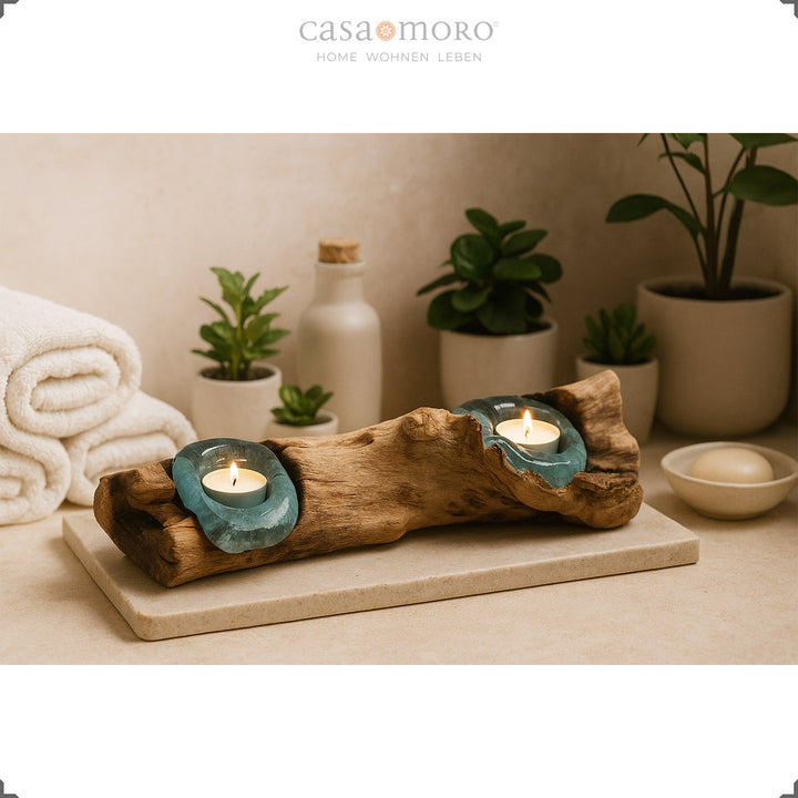 2 värmeljushållare gjorda av glas och burl-trä i badrummet, dess mjuka ljus kompletterar den avslappnade spa-atmosfären med växter och handdukar.